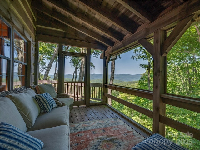 unfurnished sunroom with a healthy amount of sunlight, wooden ceiling, and lofted ceiling with beams