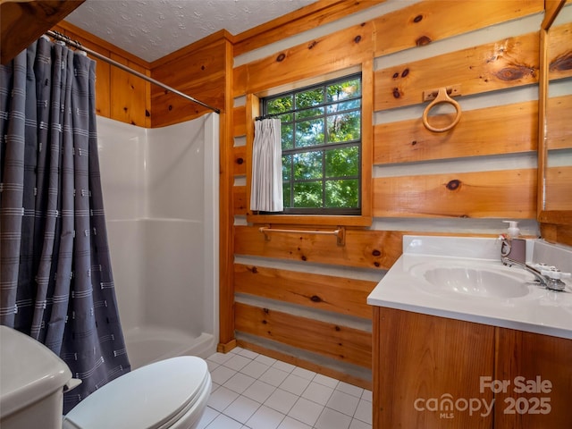 bathroom featuring curtained shower, a textured ceiling, tile patterned floors, vanity, and toilet