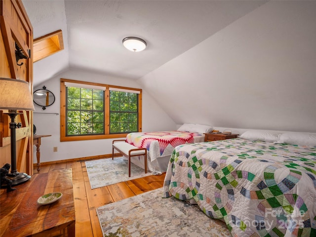 bedroom with hardwood / wood-style floors and vaulted ceiling