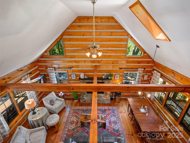 unfurnished living room with hardwood / wood-style flooring, high vaulted ceiling, and a skylight