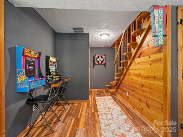 playroom featuring wood-type flooring and a textured ceiling