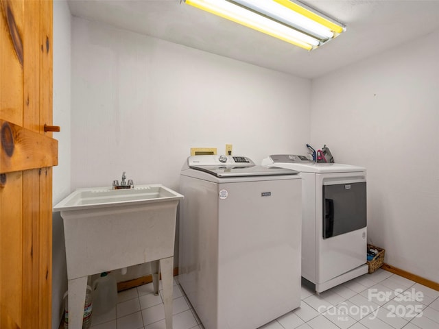 clothes washing area featuring light tile patterned floors and washer and clothes dryer