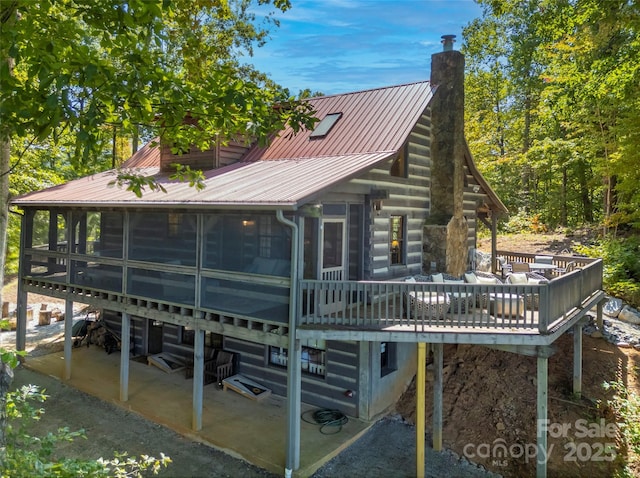 rear view of property featuring a sunroom, a patio, and a water view