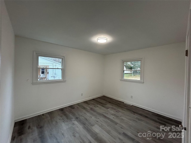 spare room with dark hardwood / wood-style floors