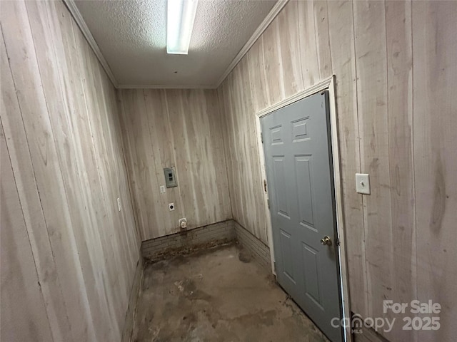 corridor featuring a textured ceiling and wood walls