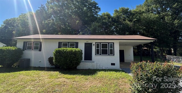 2334 Woodleaf Dr, Gastonia, NC 28052 - view of front facade with brick siding, a carport, a front lawn, and central AC unit