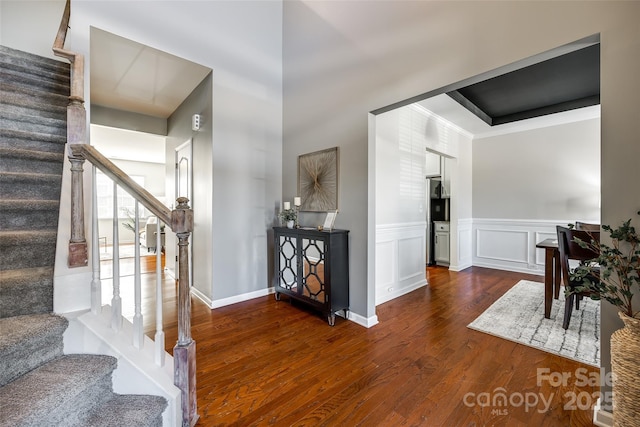 foyer entrance with ornamental molding and dark hardwood / wood-style floors