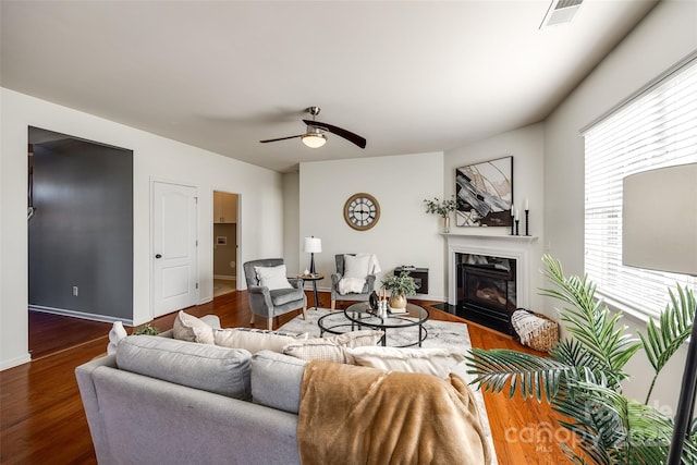 living room with dark wood-type flooring and ceiling fan