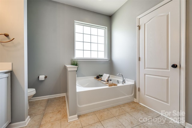 bathroom featuring tile patterned flooring, a bath, vanity, and toilet