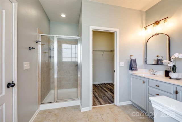 bathroom with tile patterned floors, a shower with door, and vanity