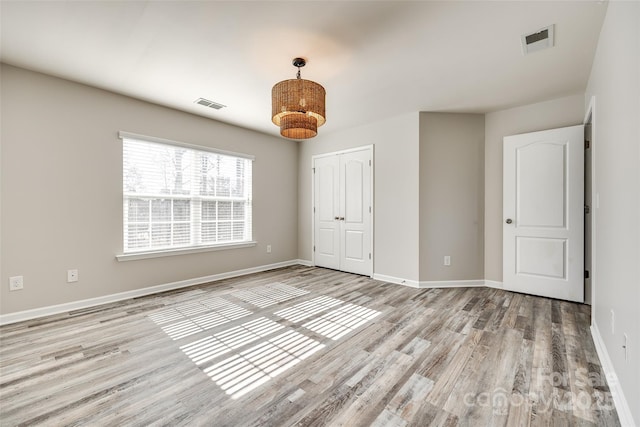 unfurnished bedroom with a closet and light hardwood / wood-style flooring