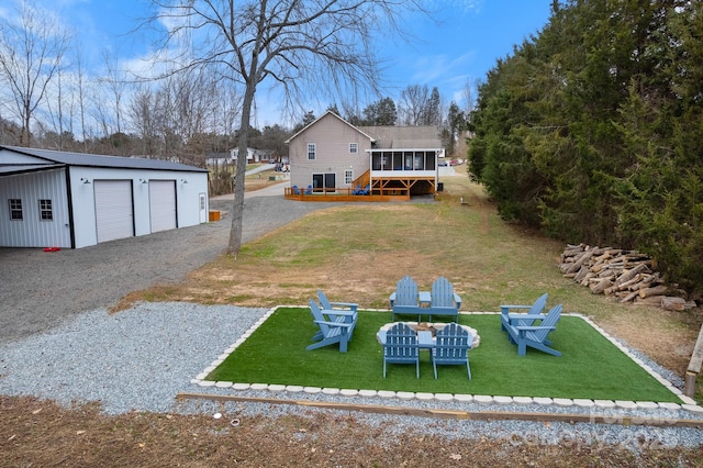 view of yard featuring a garage, a sunroom, a deck, and an outdoor structure