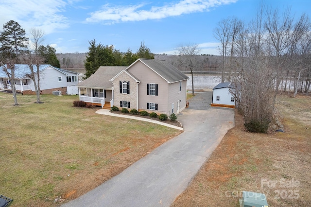 view of front of house with a garage, covered porch, and a front yard