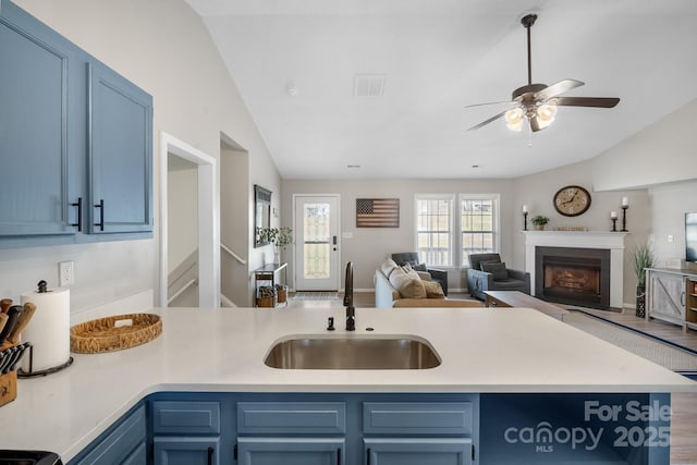 kitchen featuring blue cabinets, lofted ceiling, sink, hardwood / wood-style flooring, and ceiling fan