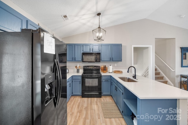 kitchen featuring black appliances, sink, hanging light fixtures, kitchen peninsula, and blue cabinetry