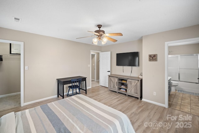 bedroom featuring ensuite bathroom, a walk in closet, light hardwood / wood-style flooring, a closet, and ceiling fan