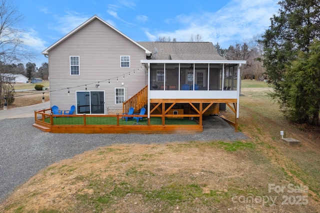 rear view of property featuring a sunroom