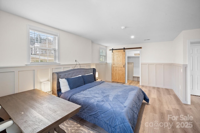 bedroom featuring light hardwood / wood-style floors and a barn door