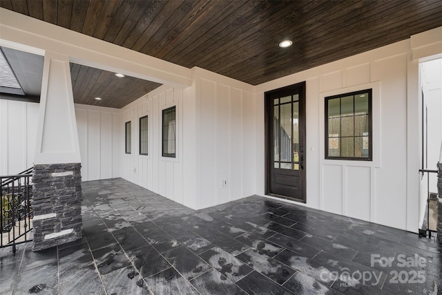 view of exterior entry with a porch and board and batten siding