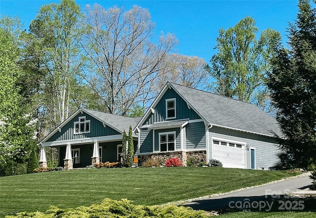 craftsman inspired home with a garage, a front yard, and covered porch