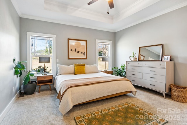 bedroom with crown molding, a tray ceiling, carpet flooring, and multiple windows