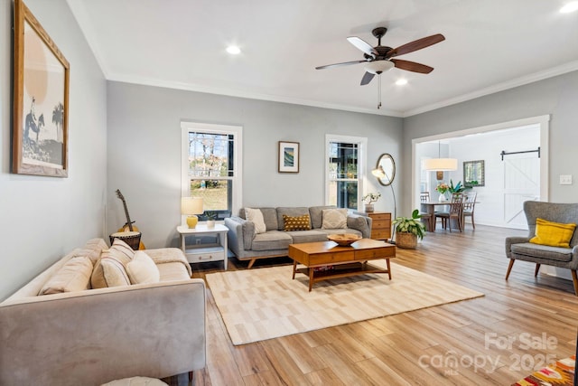 living room with hardwood / wood-style flooring, ornamental molding, and ceiling fan