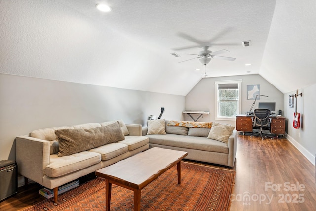 living room featuring hardwood / wood-style flooring, ceiling fan, lofted ceiling, and a textured ceiling