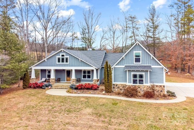 craftsman-style home featuring covered porch and a front lawn