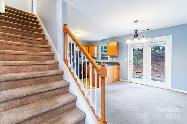 staircase with carpet and an inviting chandelier