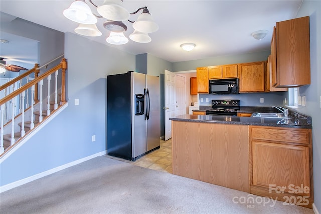 kitchen featuring sink, hanging light fixtures, kitchen peninsula, ceiling fan with notable chandelier, and black appliances