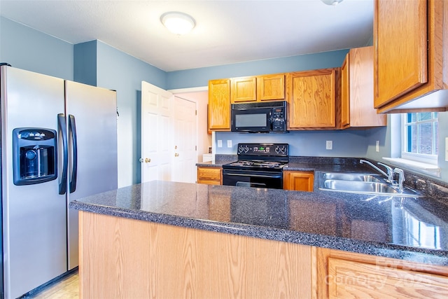 kitchen with sink, dark stone counters, and black appliances