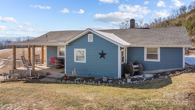 rear view of property featuring a lawn and a patio