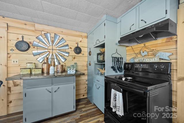 kitchen featuring dark wood-type flooring, wooden walls, blue cabinetry, and black range with electric cooktop