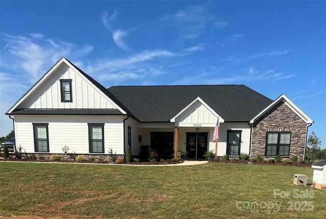 modern inspired farmhouse featuring a front yard, board and batten siding, and stone siding