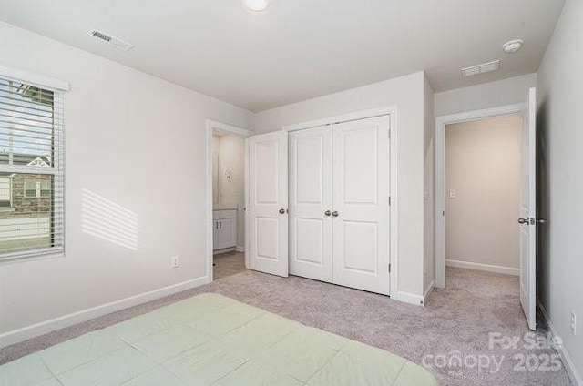 unfurnished bedroom with a closet and light carpet