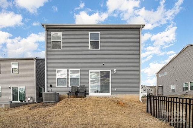 back of property featuring central AC unit and a lawn