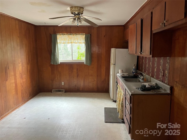 kitchen featuring sink and wooden walls