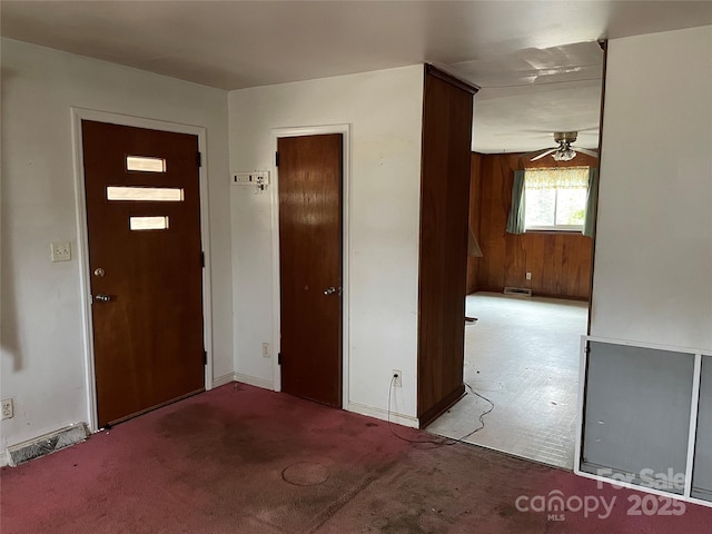 foyer entrance with ceiling fan and light colored carpet