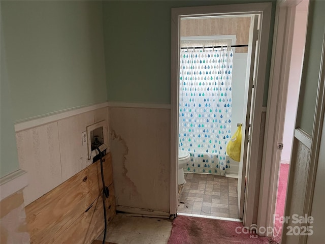 bathroom featuring toilet and shower / bathtub combination with curtain