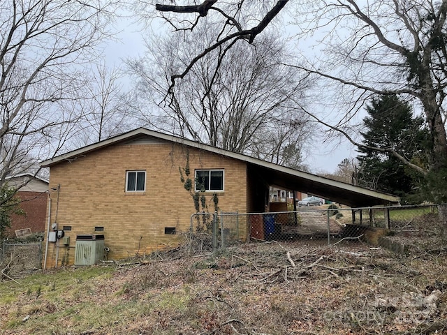 view of home's exterior featuring cooling unit and a carport