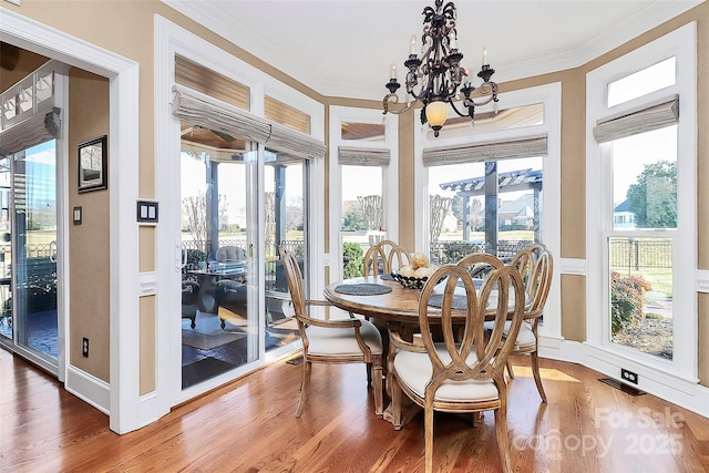 sunroom / solarium featuring an inviting chandelier and a healthy amount of sunlight