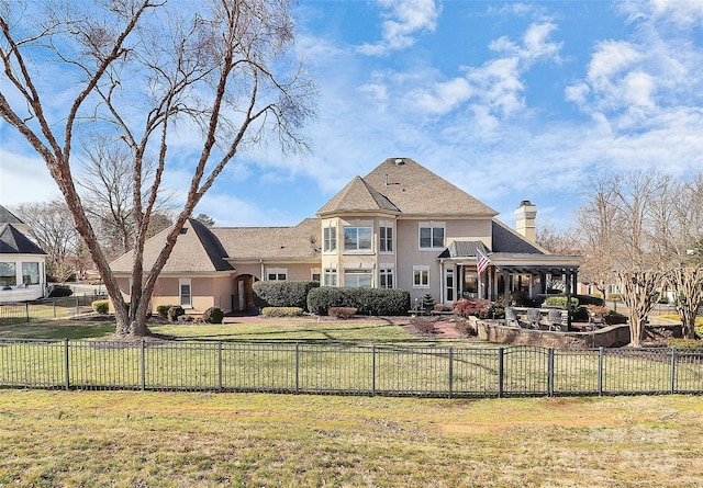 rear view of property featuring a lawn and a patio area