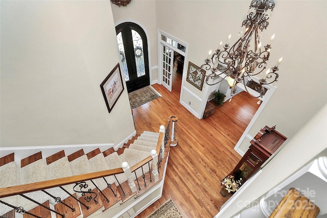 foyer featuring french doors, wood-type flooring, and a high ceiling