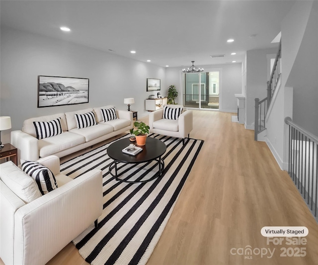 living room featuring a chandelier and light wood-type flooring