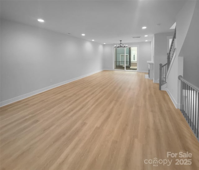 unfurnished living room featuring light hardwood / wood-style flooring and a notable chandelier