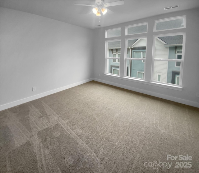 carpeted spare room with ceiling fan