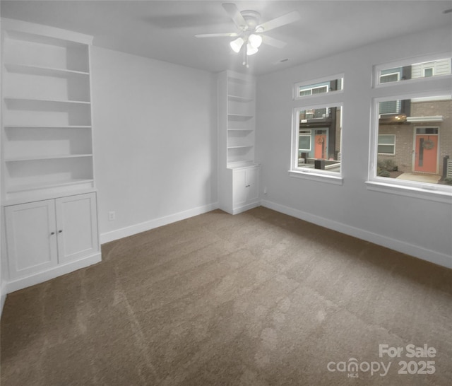 carpeted empty room with ceiling fan and built in features