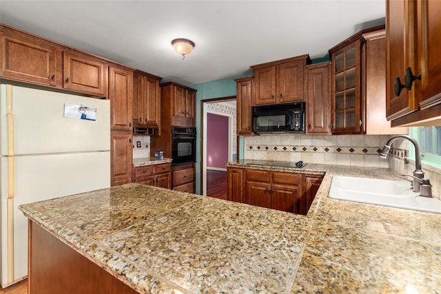 kitchen featuring sink, black appliances, tasteful backsplash, and kitchen peninsula