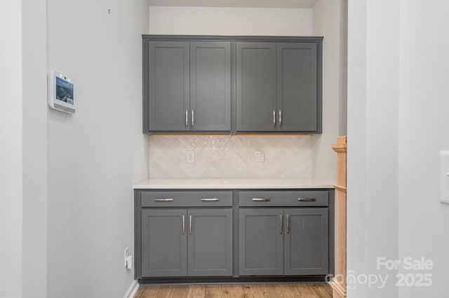 kitchen with gray cabinetry, tasteful backsplash, and light hardwood / wood-style floors