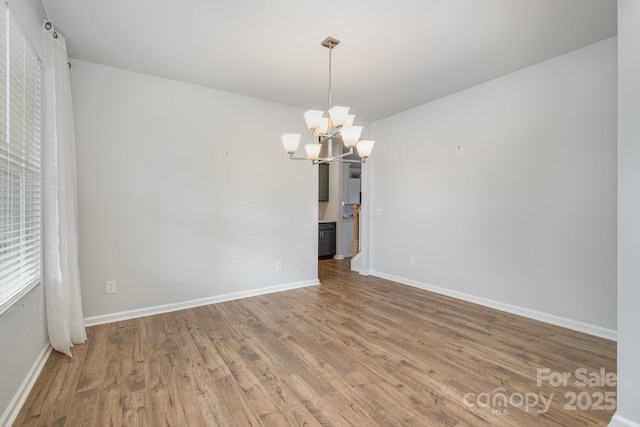 unfurnished dining area with hardwood / wood-style floors and a chandelier